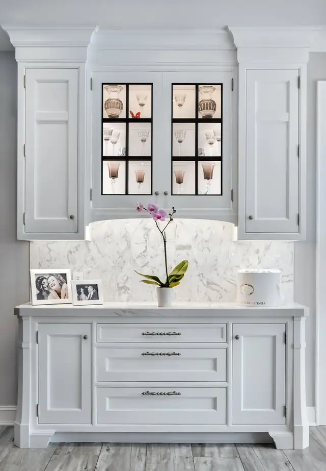Custom white RUTT cabinetry hutch with glass upper doors, marble backsplash and display counter