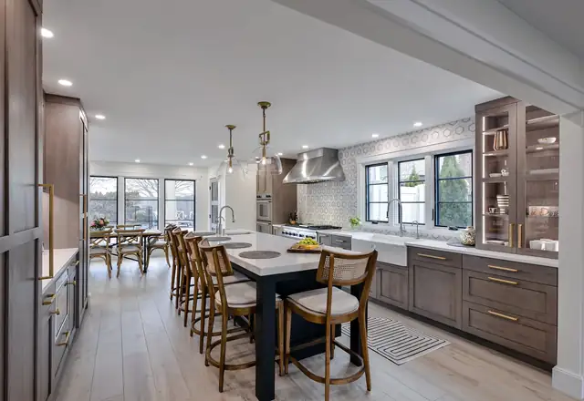 South Shore Long Island open kitchen remodel with walnut-toned cabinets, a long island with counter stools and pendant lights