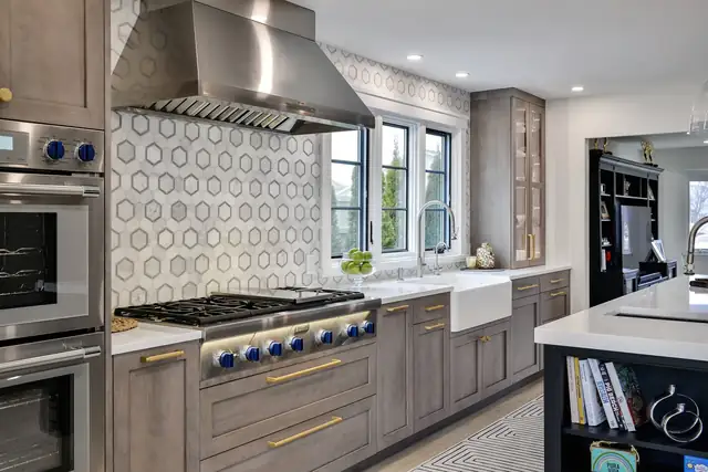 Long Island open-concept RUTT kitchen with a Thermador rangetop, stainless hood and hexagon marble backsplash