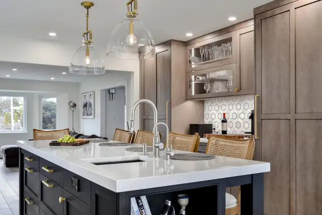 Kitchen with gray oak cabinetry, a black island with a white counter, glass pendants and a patterned tile backsplash