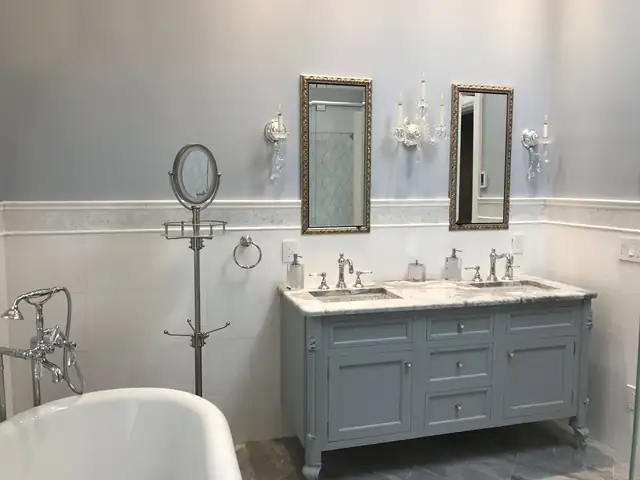 Traditional bathroom with a gray furniture-style vanity, marble top, framed mirrors and freestanding tub