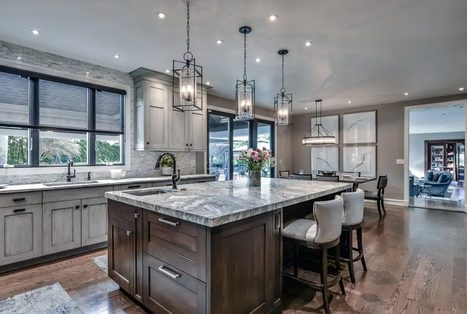 Luxury kitchen remodeling Manhasset area: Glen Head kitchen with soft gray glazed RUTT cabinets, a quartzite island and lantern pendants